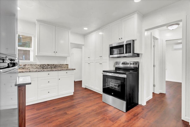 kitchen with white cabinetry, dark hardwood / wood-style floors, stainless steel appliances, and light stone counters