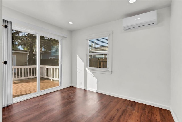 empty room with dark wood-type flooring and a wall mounted air conditioner