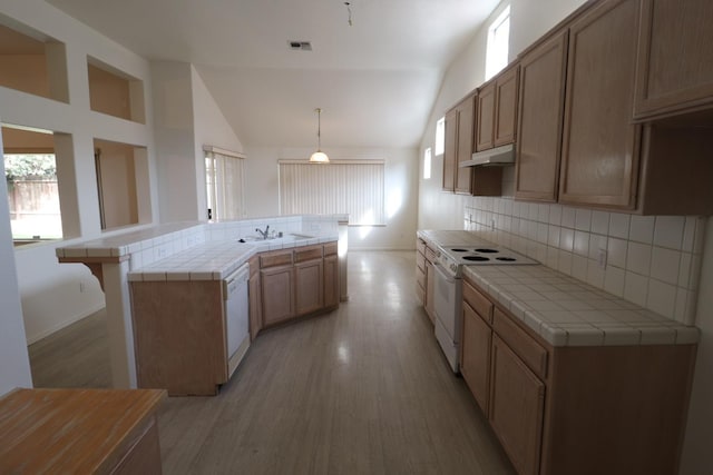 kitchen featuring tile countertops, white appliances, decorative light fixtures, sink, and kitchen peninsula