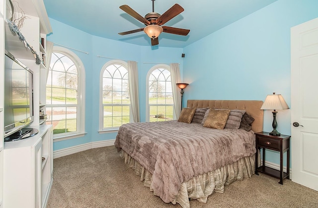 bedroom featuring a ceiling fan, light carpet, and baseboards