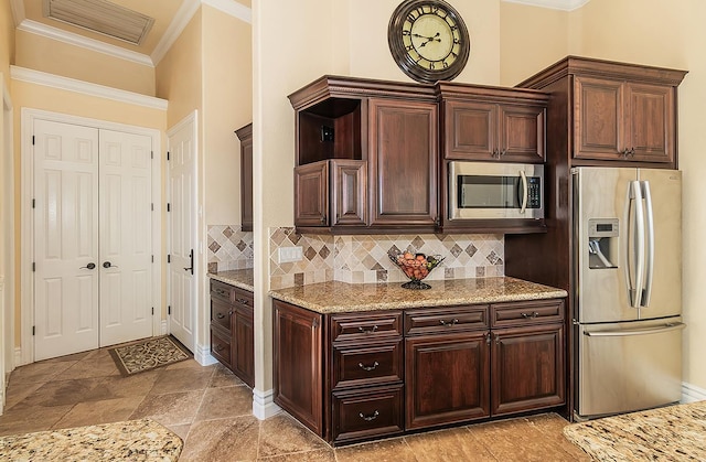 14505 Blue Drake Ln, Prather, CA 93651 - kitchen featuring appliances with stainless steel finishes, ornamental molding, tasteful backsplash, dark brown cabinetry, and light stone countertops