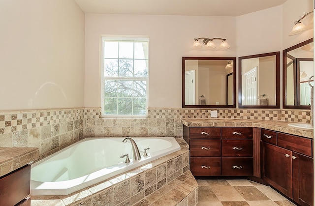 bathroom with a sink, a bath, and double vanity