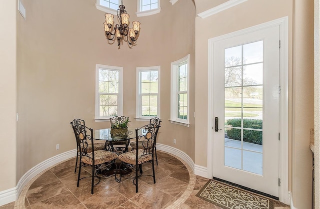 14505 Blue Drake Ln, Prather, CA 93651 - dining room featuring plenty of natural light, a chandelier, stone finish floors, and a towering ceiling