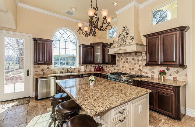 kitchen featuring range, a center island, custom exhaust hood, stainless steel dishwasher, and a sink