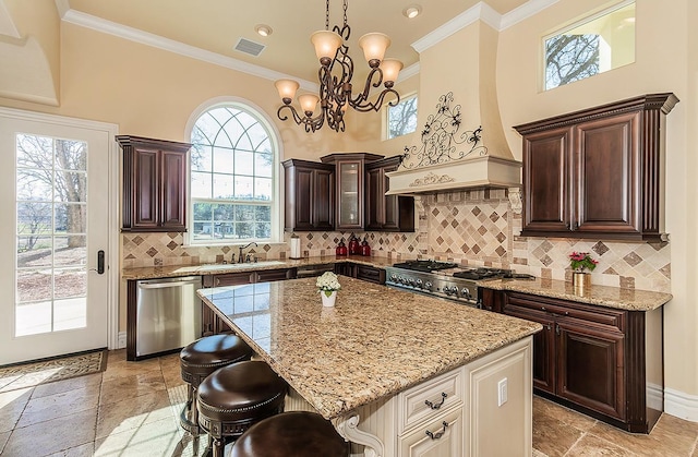 14505 Blue Drake Ln, Prather, CA 93651 - kitchen featuring stainless steel appliances, light stone counters, a breakfast bar, ornamental molding, and a chandelier