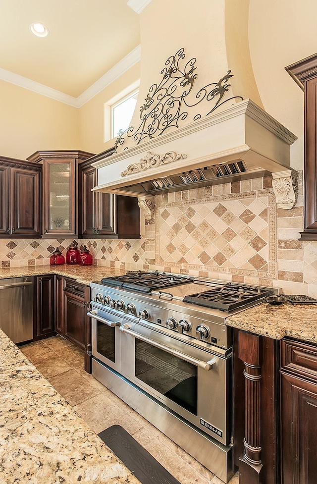 kitchen featuring appliances with stainless steel finishes, crown molding, glass insert cabinets, and light stone countertops