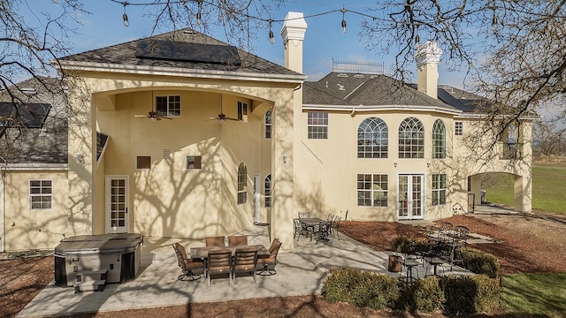 rear view of house with ceiling fan, a patio, french doors, and stucco siding