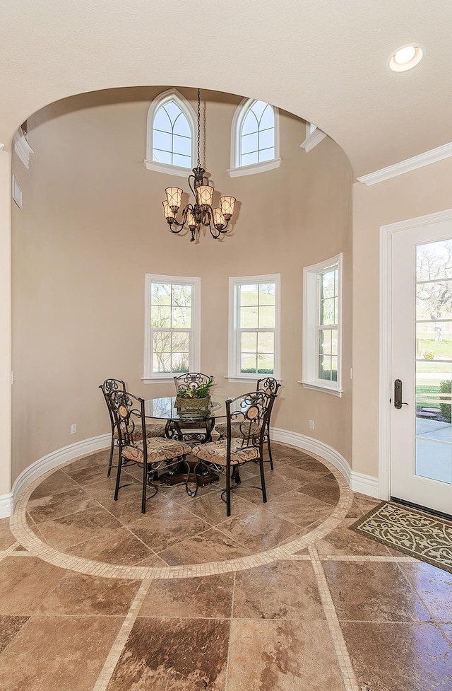 14505 Blue Drake Ln, Prather, CA 93651 - dining area featuring a chandelier, arched walkways, inlaid floor details, recessed lighting, and ornamental molding