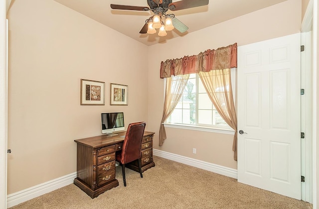 home office featuring light carpet, a ceiling fan, and baseboards