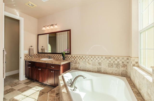 bathroom featuring a garden tub and vanity