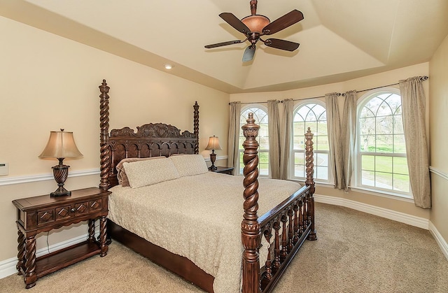 bedroom with a raised ceiling, light carpet, ceiling fan, and baseboards