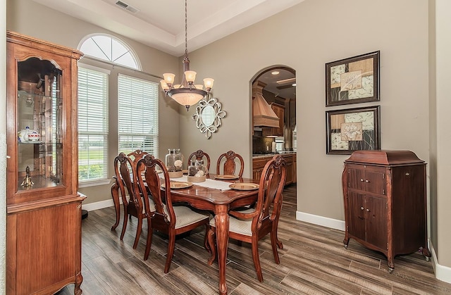 dining room with an inviting chandelier, wood finished floors, visible vents, and baseboards