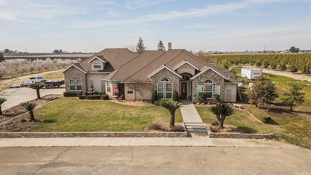 view of front of home featuring a front lawn, a rural view, and brick siding