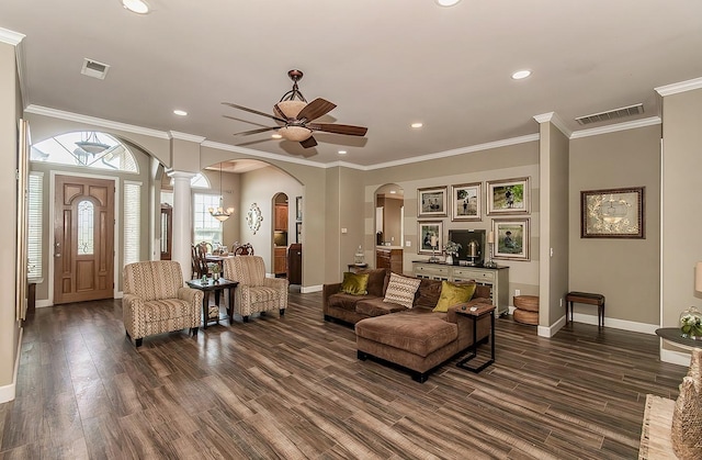 living room with arched walkways, visible vents, and crown molding