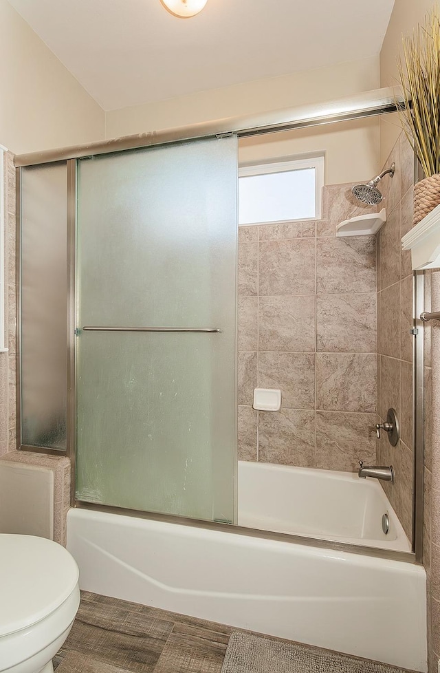 bathroom with shower / bath combination with glass door and toilet