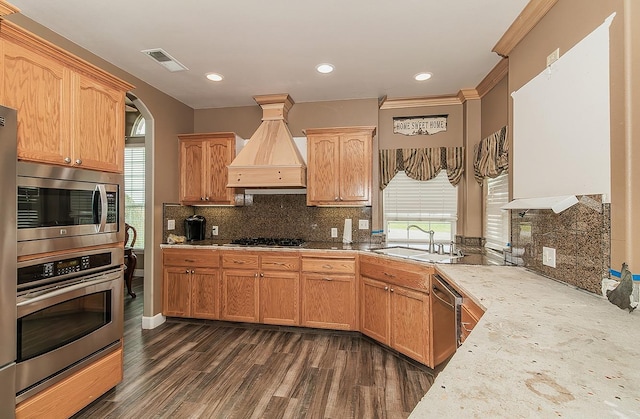 kitchen featuring premium range hood, visible vents, light countertops, appliances with stainless steel finishes, and tasteful backsplash