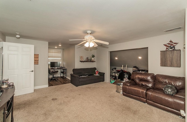 carpeted living room featuring baseboards, visible vents, and a ceiling fan