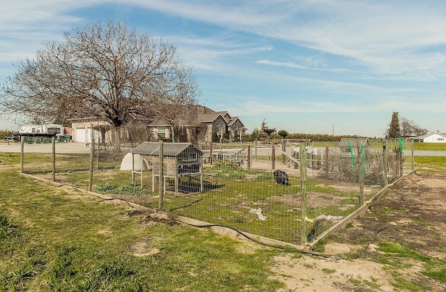 view of yard with a garage, a garden, and an outdoor structure