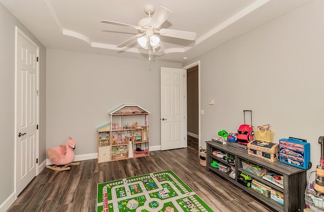 playroom featuring baseboards, dark wood finished floors, and a ceiling fan