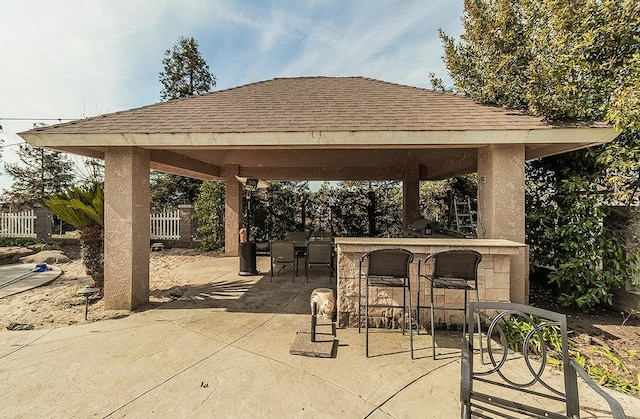 view of patio / terrace featuring outdoor dry bar, a gazebo, and fence