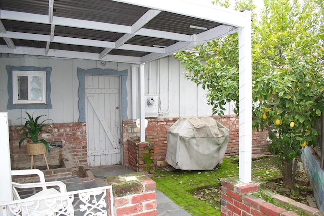 property entrance with board and batten siding and brick siding