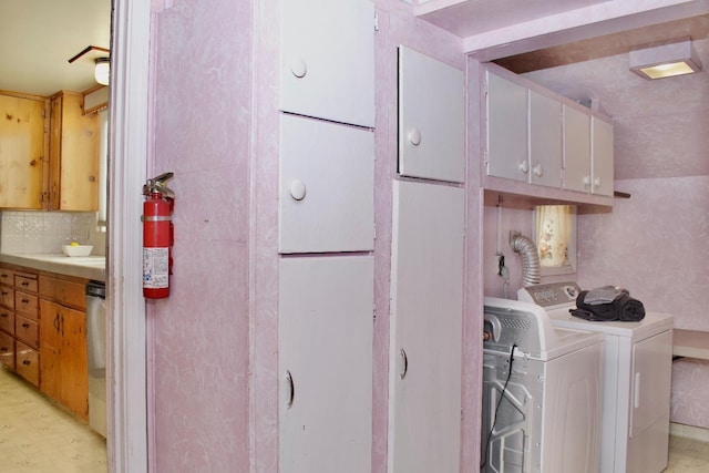 laundry area featuring cabinet space, independent washer and dryer, and light floors