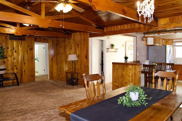 dining room with wooden ceiling, visible vents, wood walls, carpet, and ceiling fan with notable chandelier