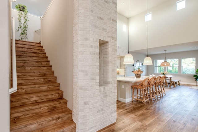 stairway featuring a high ceiling and wood finished floors