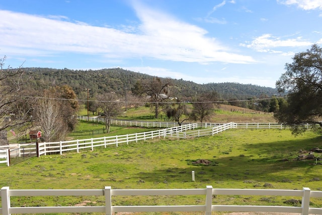 view of yard featuring a rural view, a mountain view, a forest view, and fence