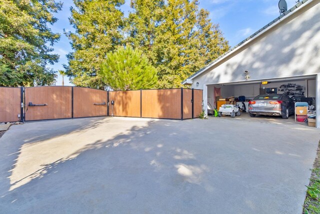 view of parking with a garage and a gate