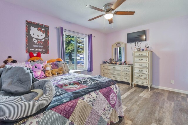 bedroom with light wood-type flooring, ceiling fan, and baseboards