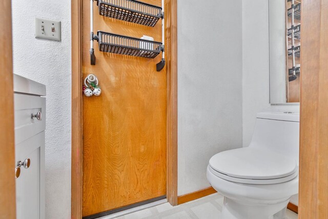 bathroom featuring toilet and baseboards