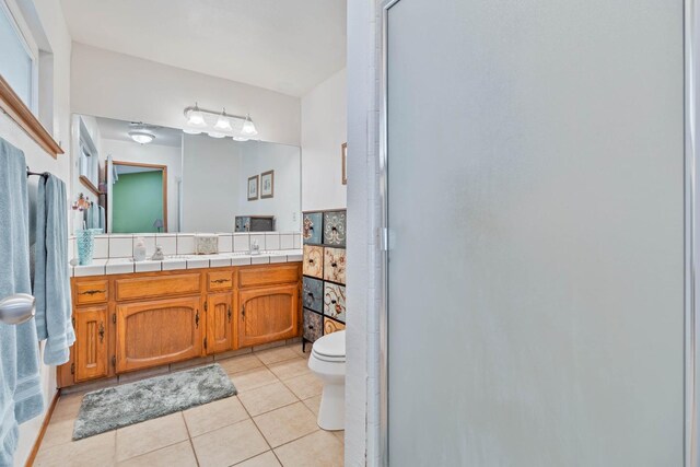 bathroom with double vanity, tile patterned flooring, and toilet