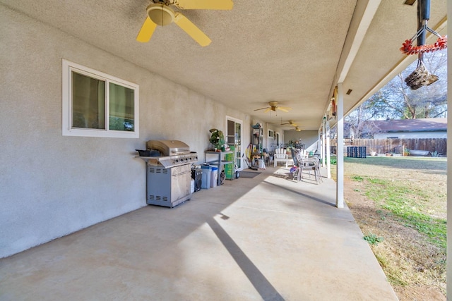 view of patio with area for grilling, fence, and a ceiling fan