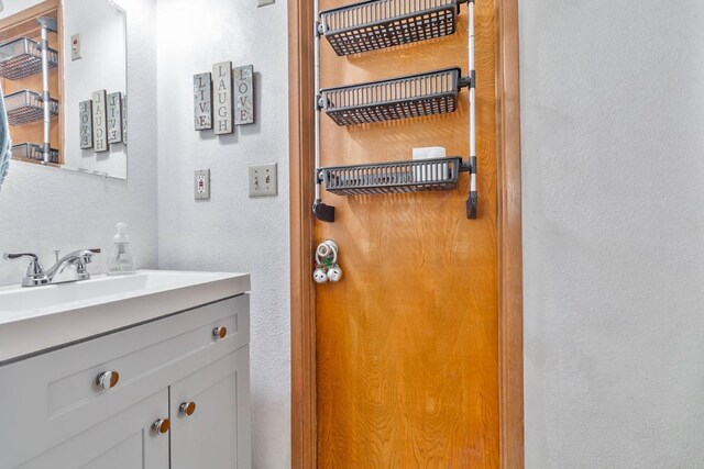 bathroom featuring a textured wall and vanity