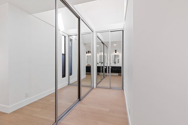 hallway with light wood-style flooring and baseboards