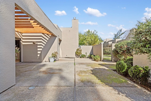 view of home's exterior featuring a gate, fence, and stucco siding