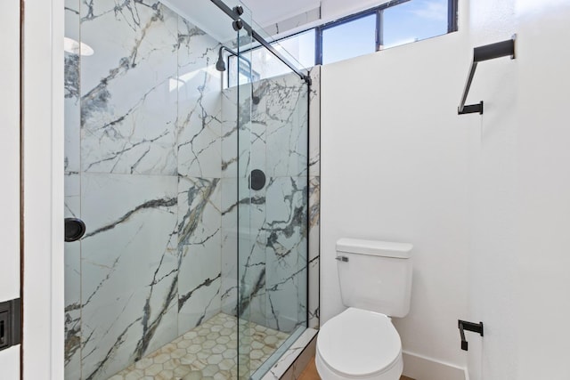 bathroom with toilet and a marble finish shower