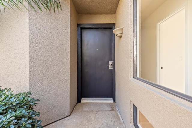 property entrance with stucco siding