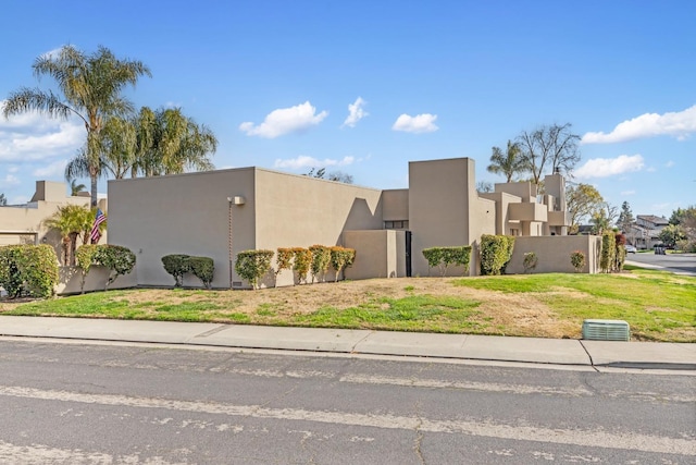 view of front of house featuring a front yard, a residential view, and stucco siding