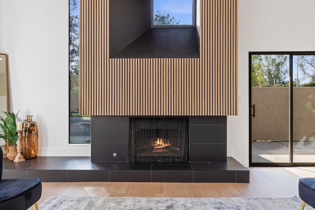 details featuring a tiled fireplace and wood finished floors