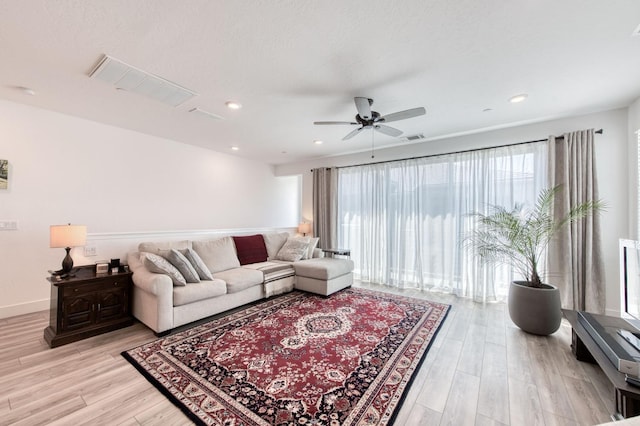 living area featuring visible vents, baseboards, light wood-style flooring, ceiling fan, and recessed lighting