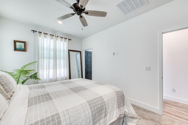 bedroom featuring light wood-type flooring, baseboards, visible vents, and ceiling fan