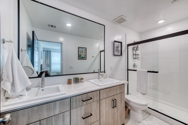 full bathroom with toilet, a sink, visible vents, a shower stall, and double vanity