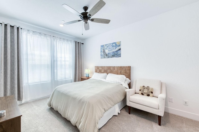 bedroom with ceiling fan, baseboards, and light colored carpet