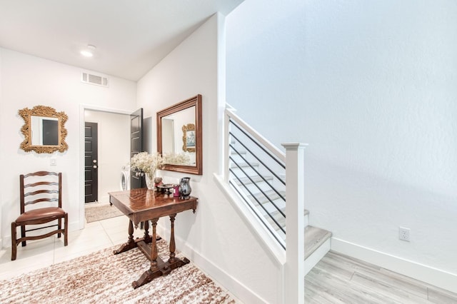 stairs with washer and clothes dryer, visible vents, and baseboards