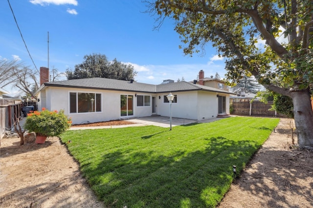 back of property with a patio area, a fenced backyard, a chimney, and a lawn