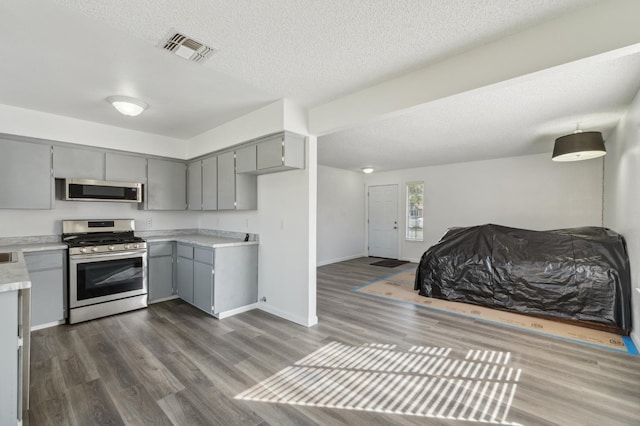 kitchen with stainless steel appliances, gray cabinets, light countertops, and visible vents