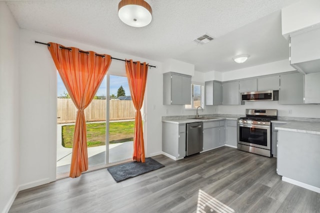 kitchen featuring a sink, stainless steel appliances, light countertops, and visible vents