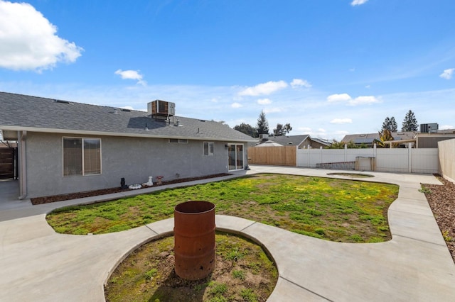 rear view of property featuring a patio, cooling unit, a fenced backyard, a lawn, and stucco siding